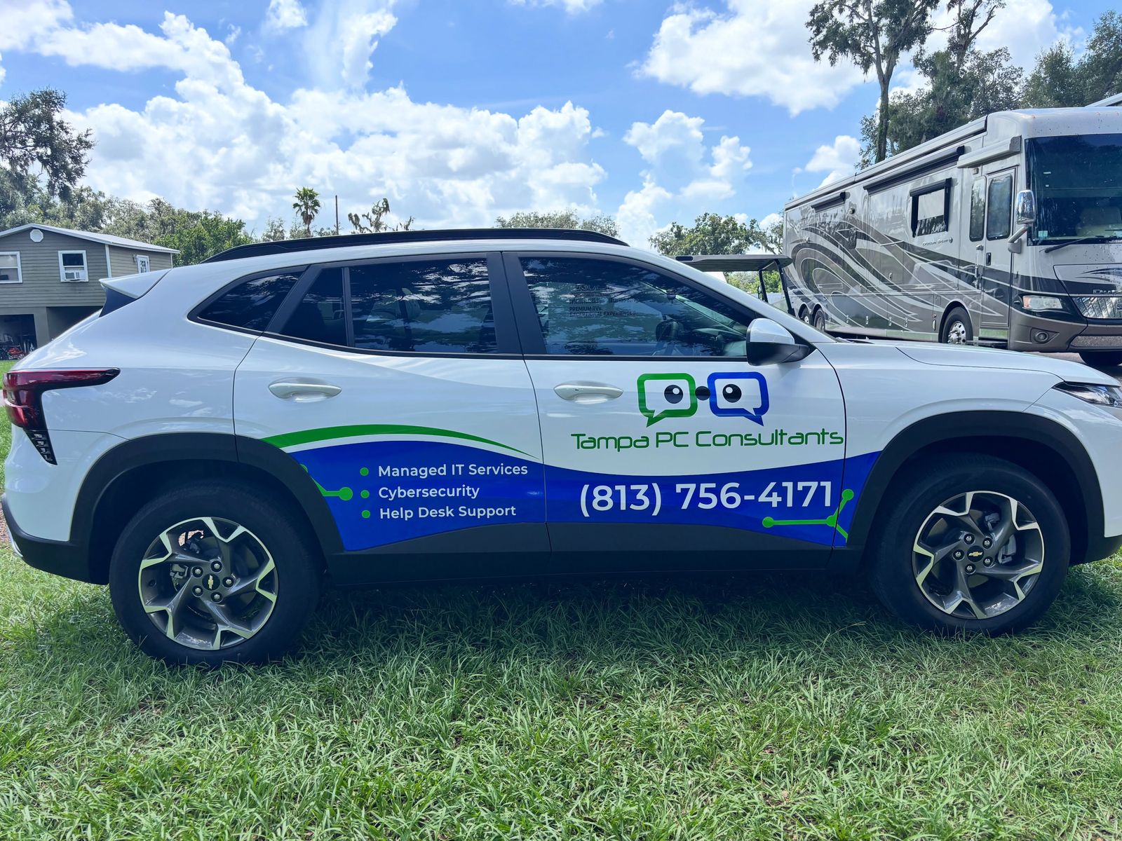 Compact SUV with printed commercial side graphics showing the logo, services and phone number